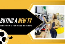 Person smiling while holding a new television in a store