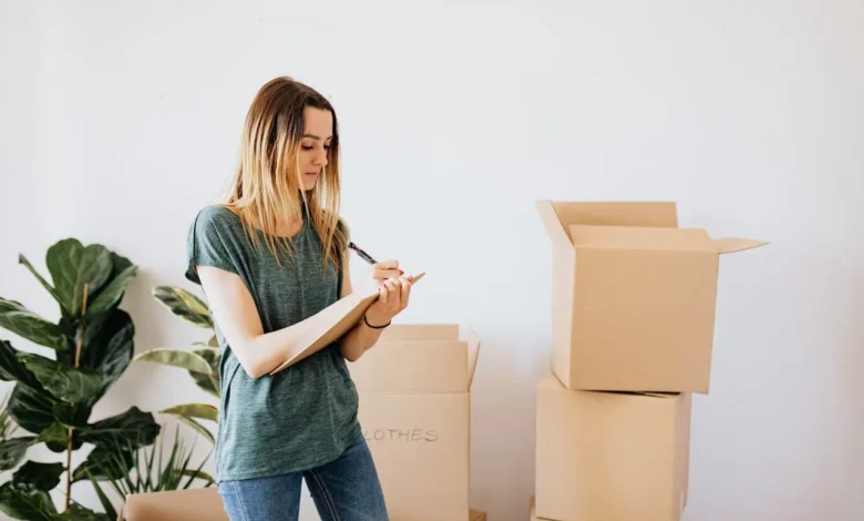 Glad woman writing down notes during while packing.