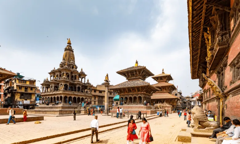 A scenic view of Patan Durbar Square in Nepal, showcasing historic temples, traditional architecture, and local visitors.