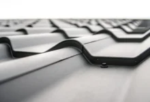 Close-up of a modern metal roof with interlocking panels, showing texture and a screw fastening point for optimal roof maintenance.