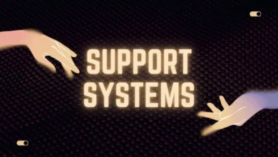 Two hands reaching across a dark textured background towards the words "SUPPORT SYSTEMS" illuminated in the center.